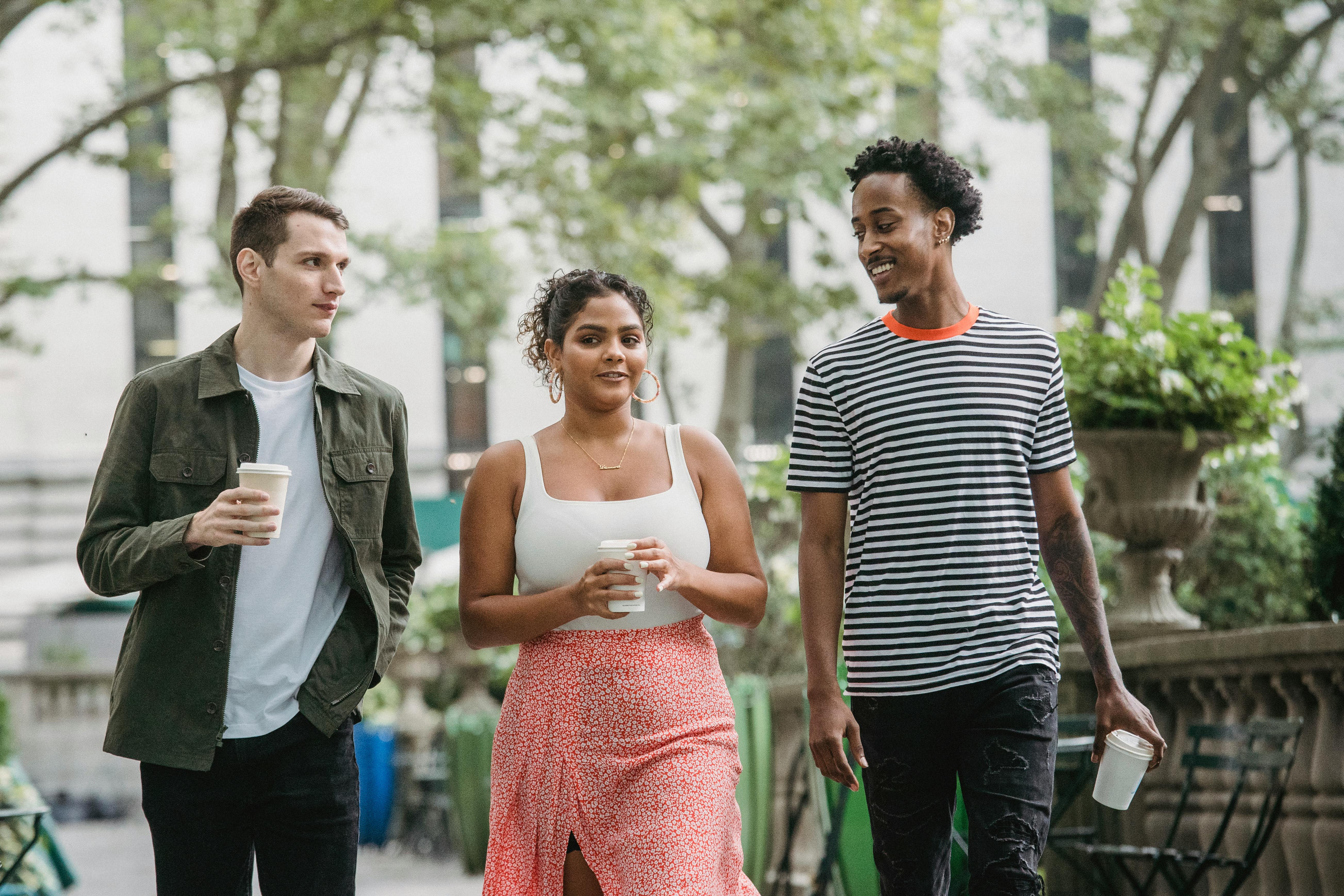 Three people walking and talking outside